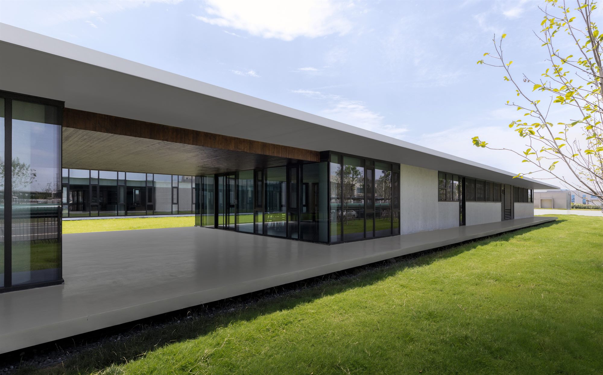 Long glazed office wing beside a landscaped lawn, Shihlien battery plant