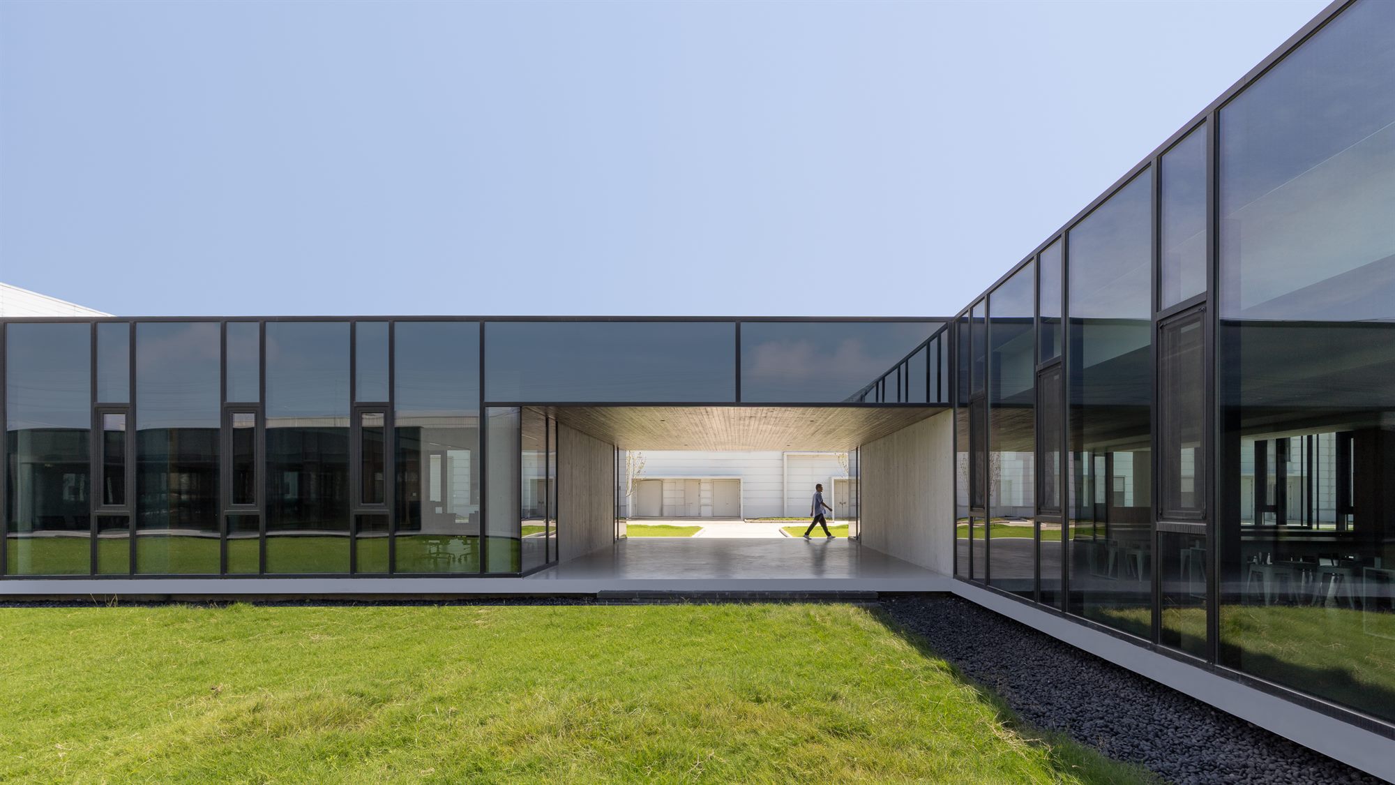Glass-walled office courtyard with green lawn, Shihlien battery plant