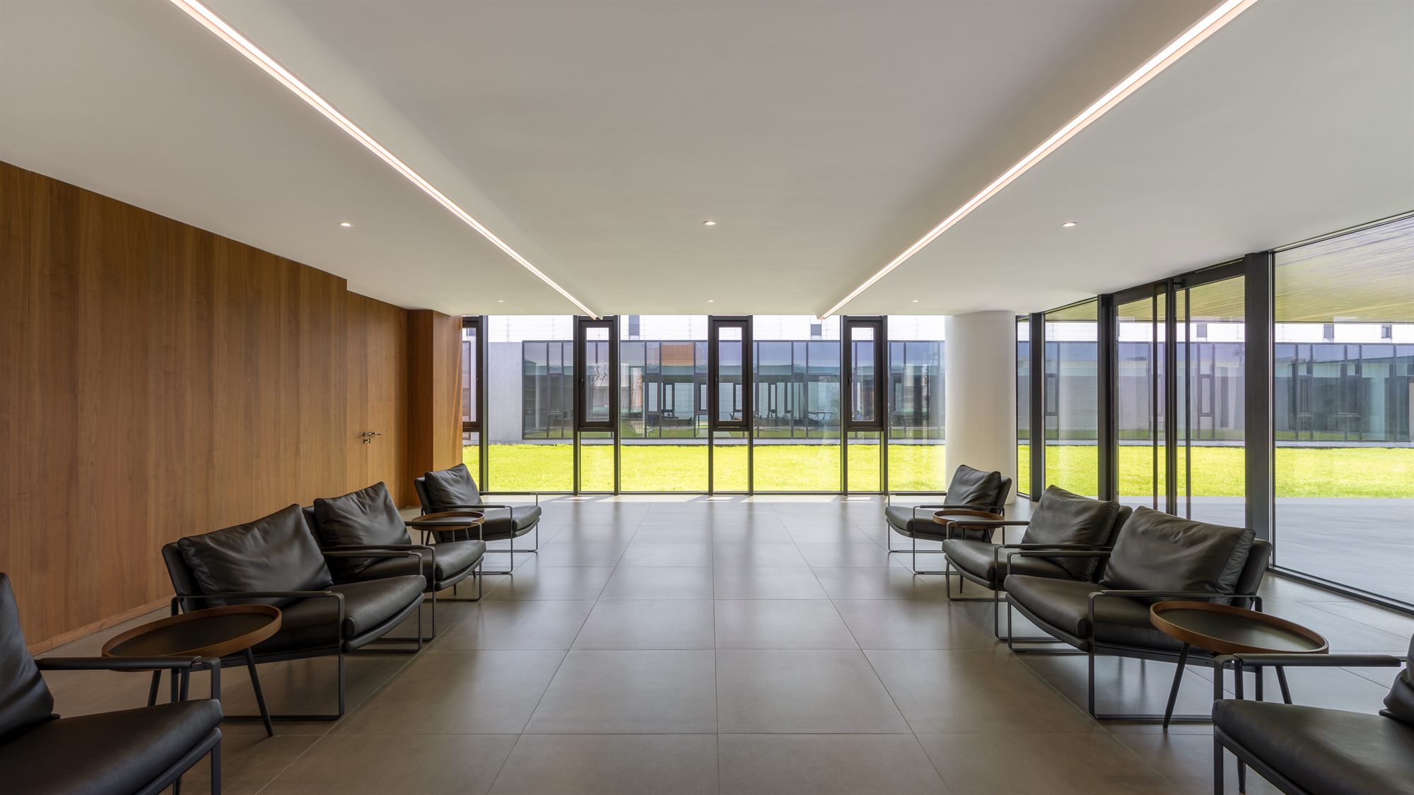 Reception lounge with timber wall and chairs overlooking the courtyard, Shihlien battery plant office