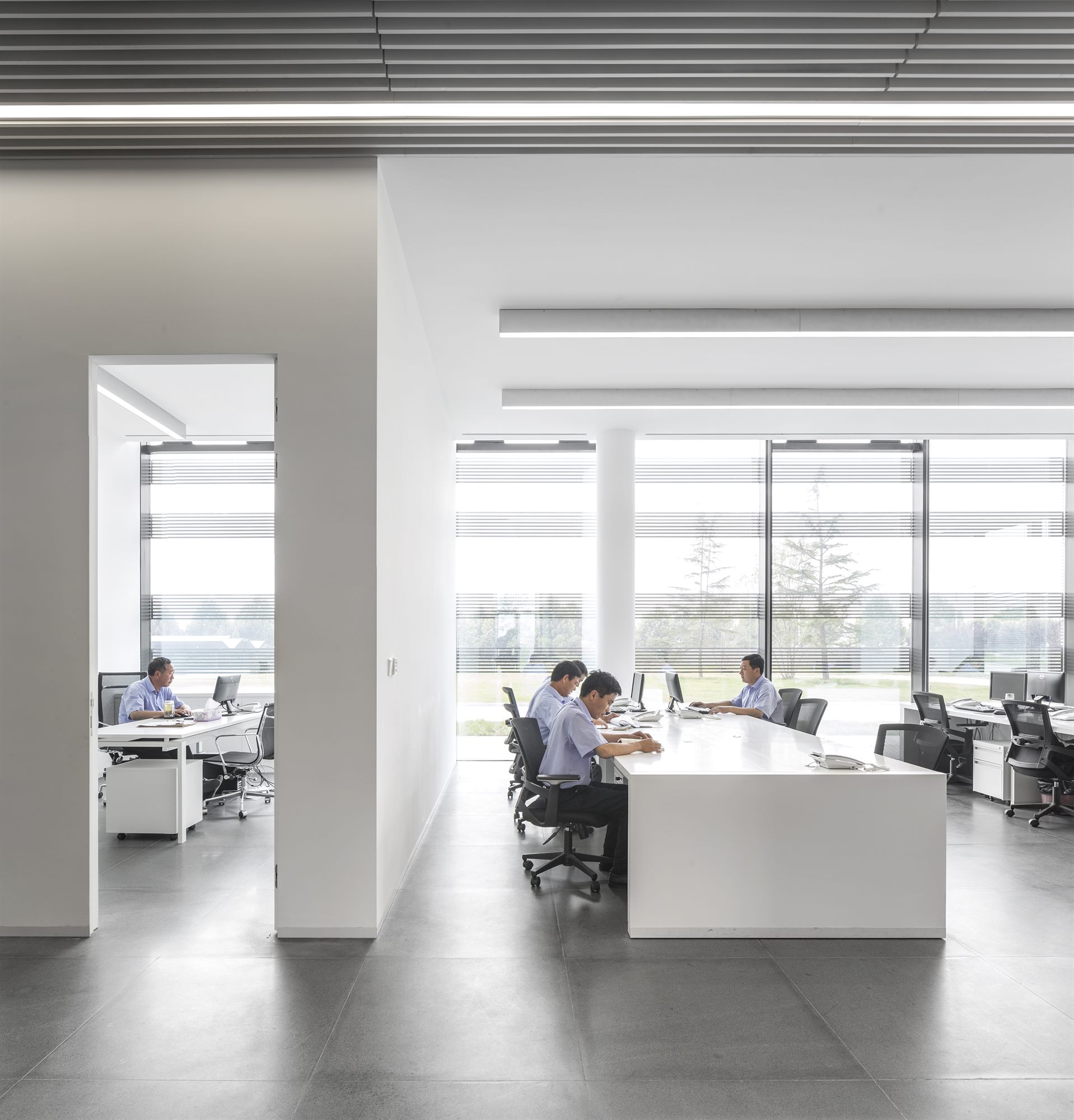 Open-plan office with white desks custom-designed by WZWX and full-height windows, Donghai office building