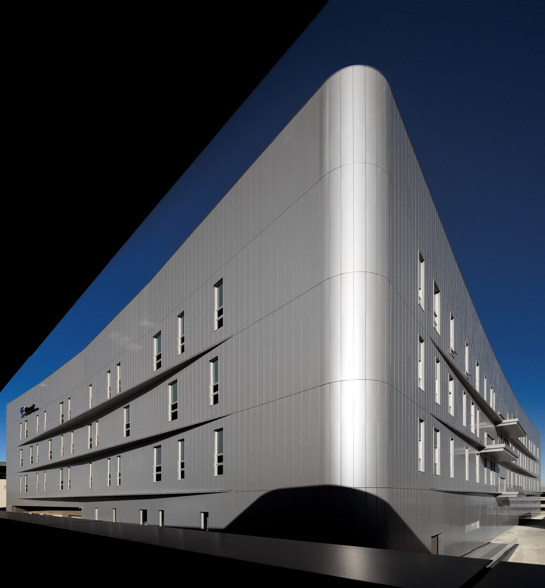 Rounded corner of the Quest Composite factory building at dusk