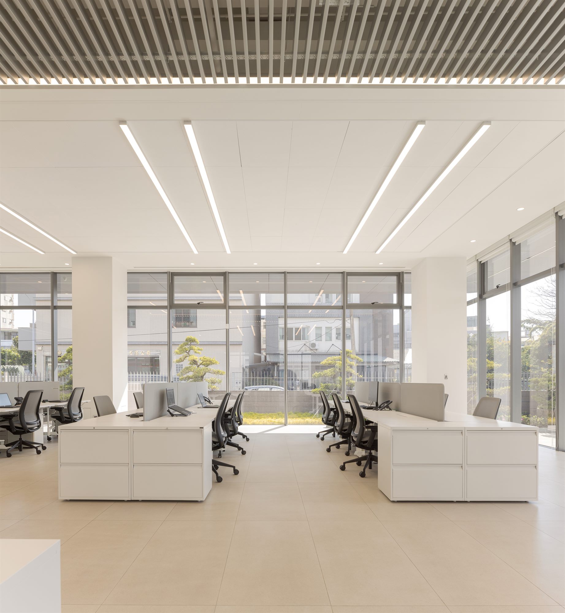 Open-plan office with long desks and linear lighting, Quest Composite