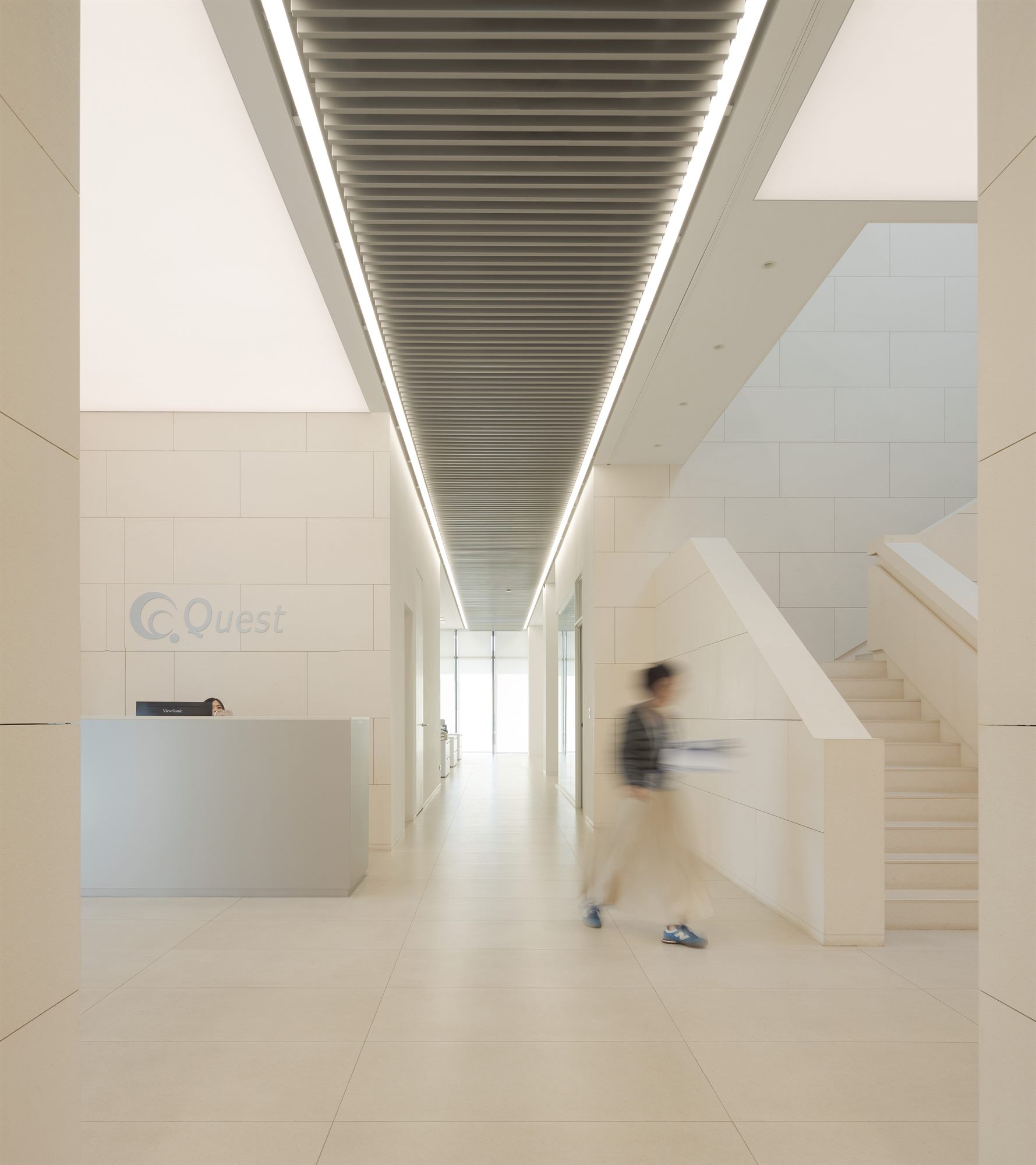 Double-height white stair hall with linear ceiling lights, Quest Composite office