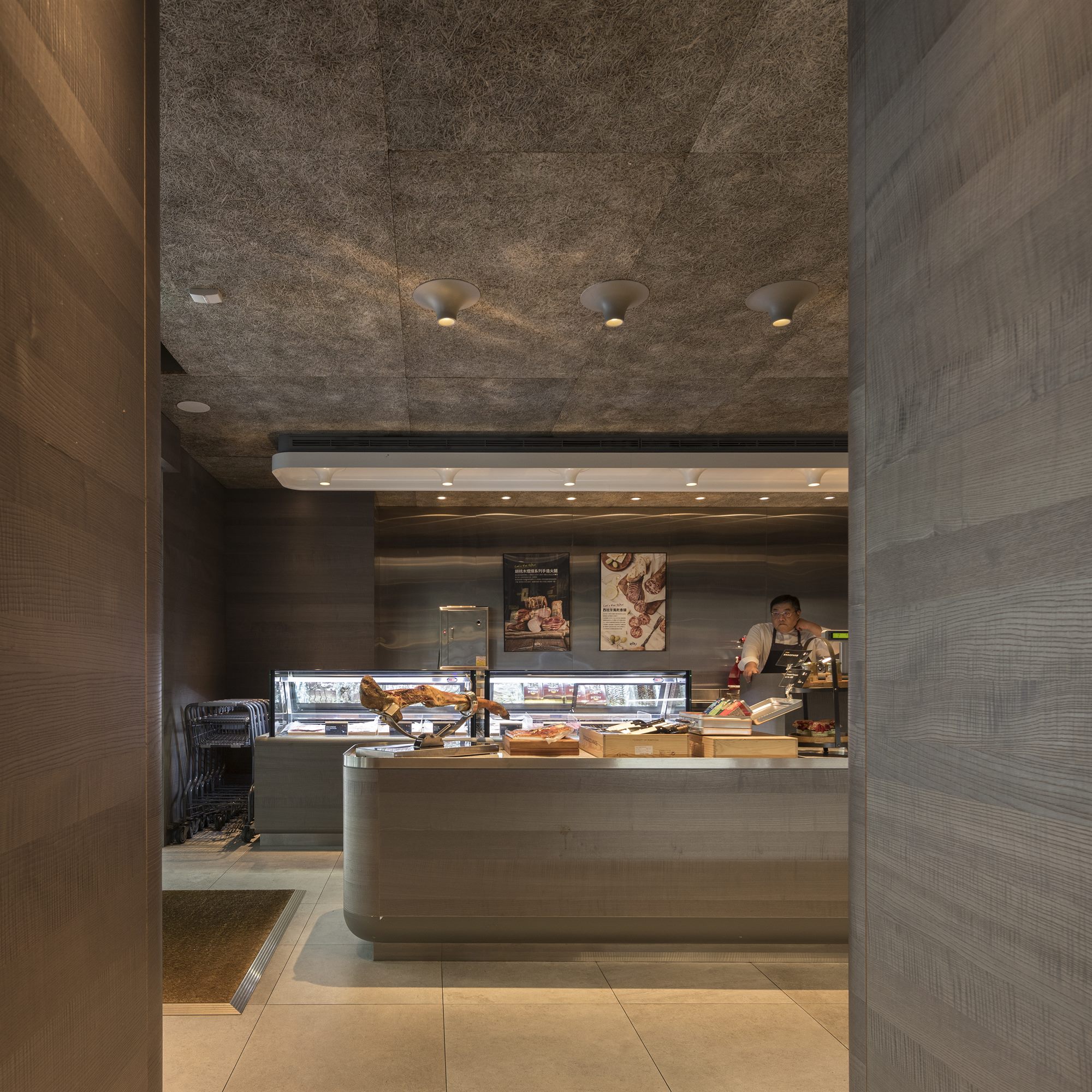 Entrance of ROU by T-HAM with stone counter and grey-toned timber walls, Taipei