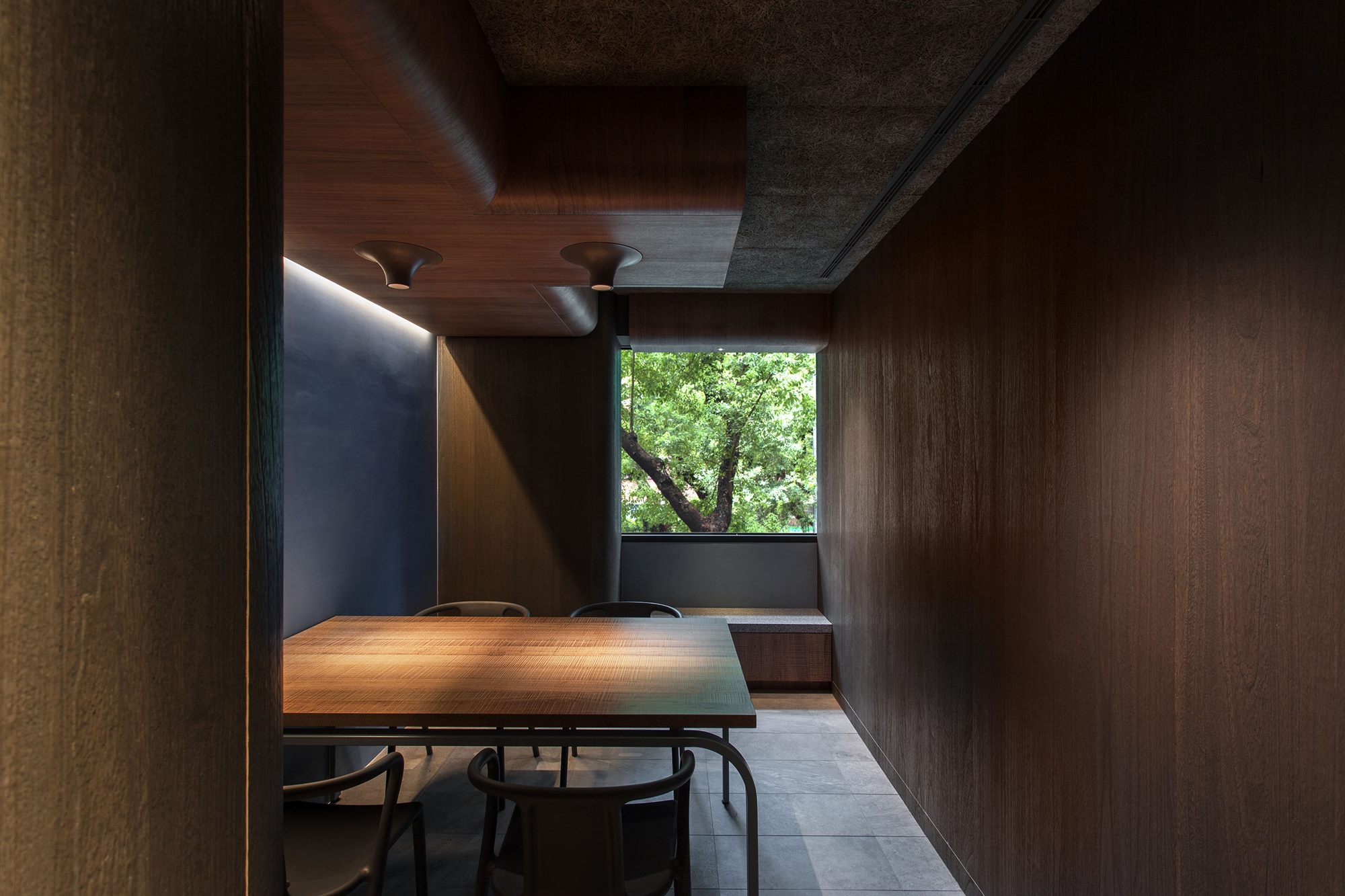 Small private room with window views and dark timber panelling, ROU by T-HAM