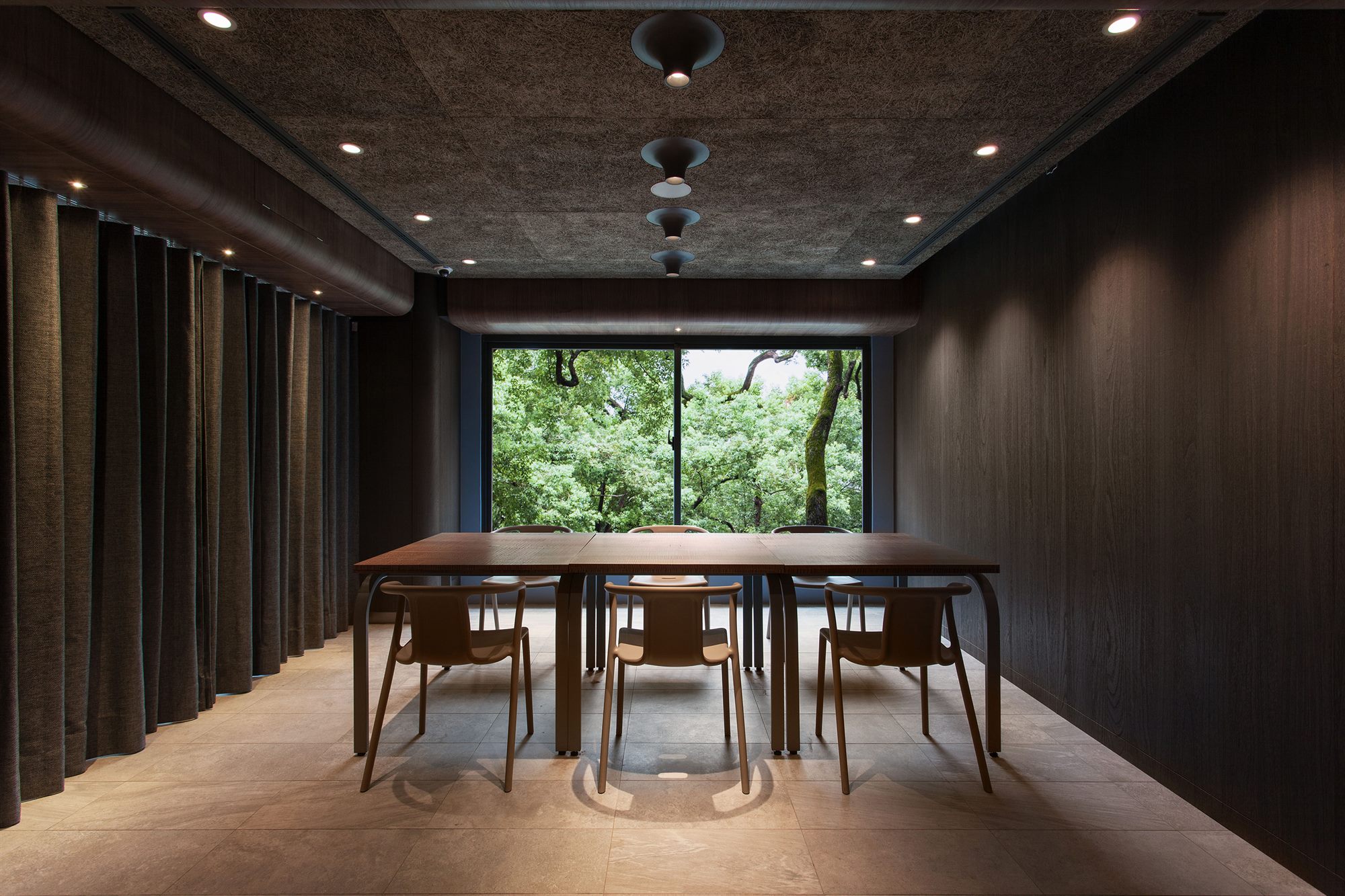 Dining area with timber table and window onto greenery, ROU by T-HAM