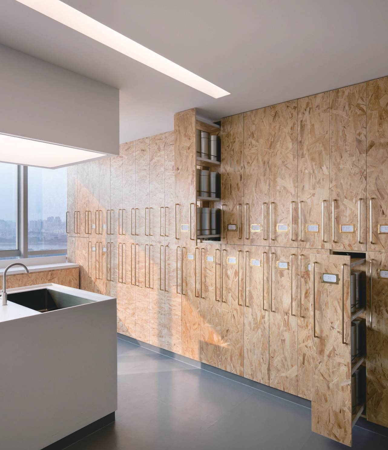 OSB sample cabinets with brass handles beside the lab counter, Shan Tea R&D lab