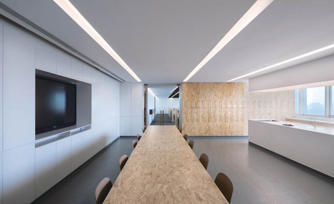 OSB meeting table with white cabinetry and the sample archive beyond, Shan Tea R&D lab