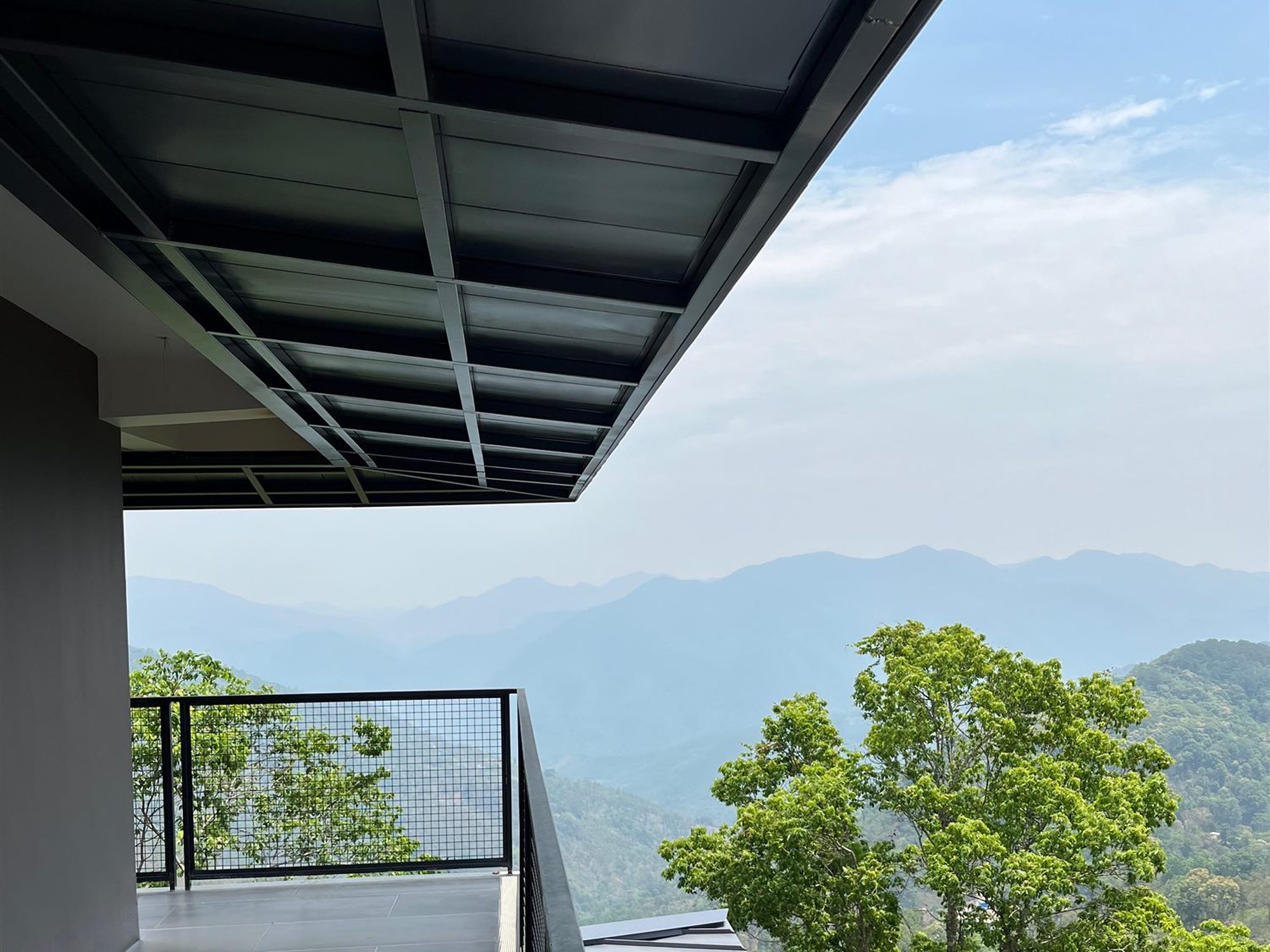 Deep roof overhang framing mountain views, Shan Tea factory