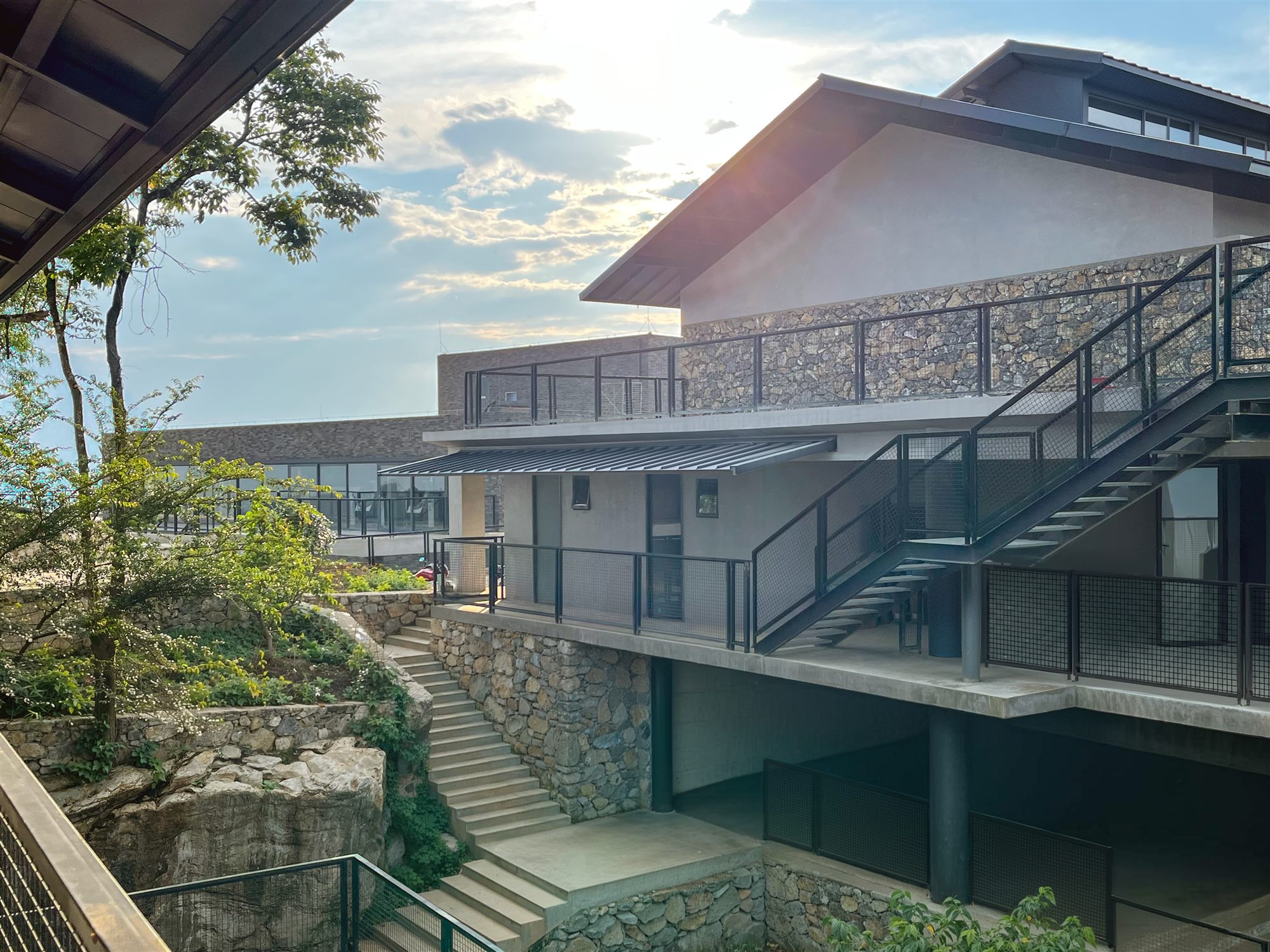 Shan Tea buildings with pitched roof and external stairs among trees