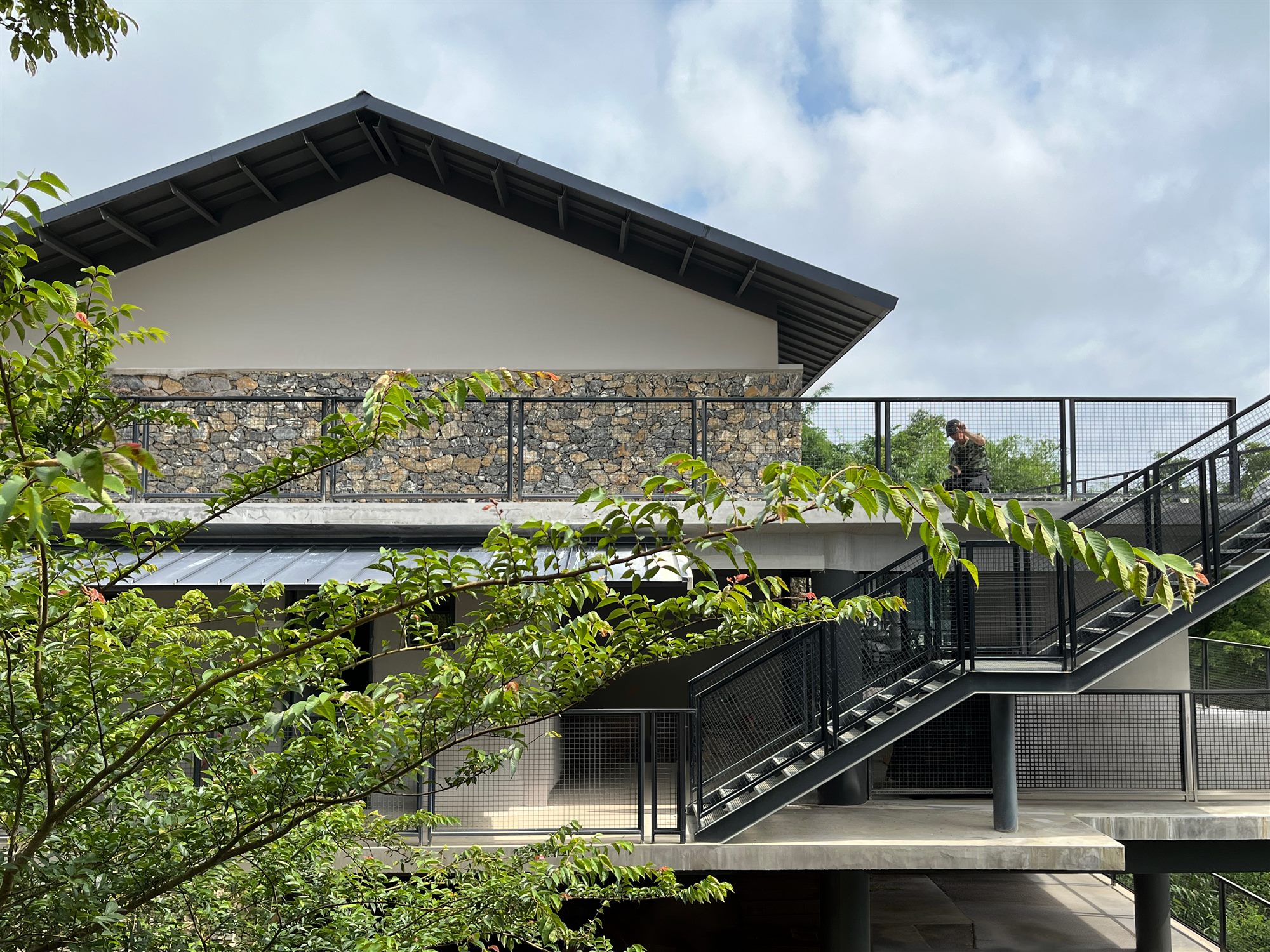 Pitched-roof Shan Tea building with steel stairs and planting