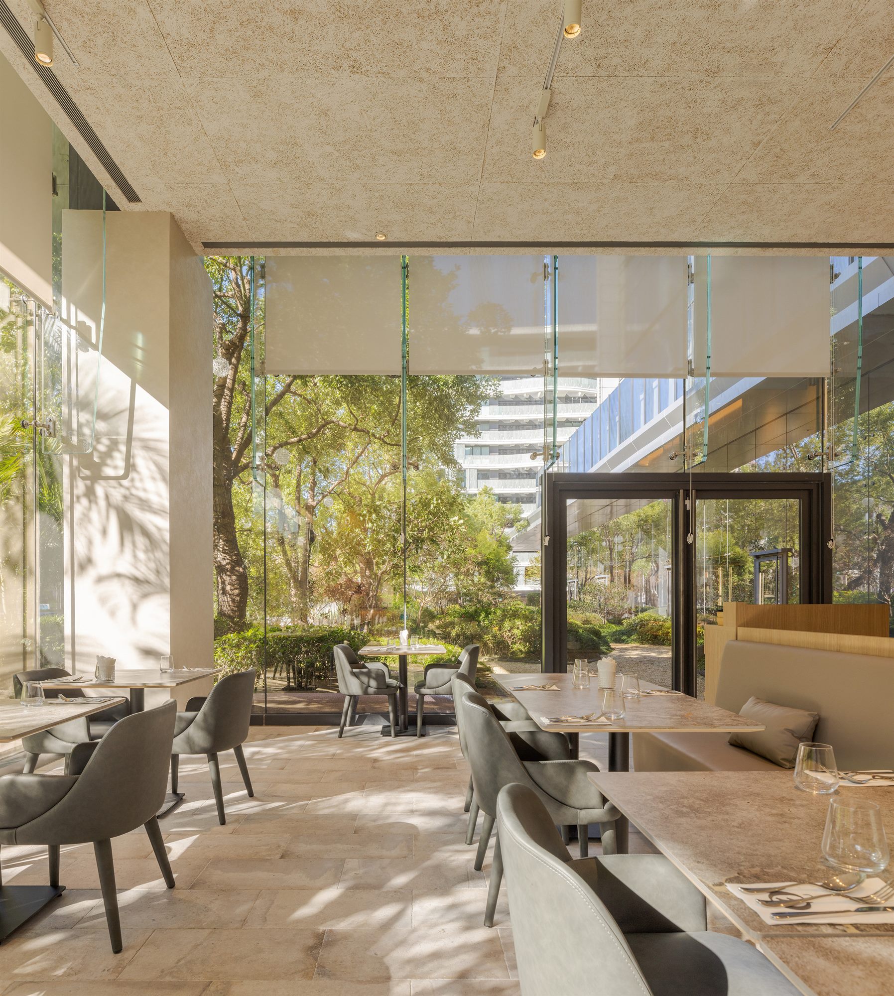 Dining room with full-height windows onto lush planting, ROU × James Sharman, Taipei Marriott