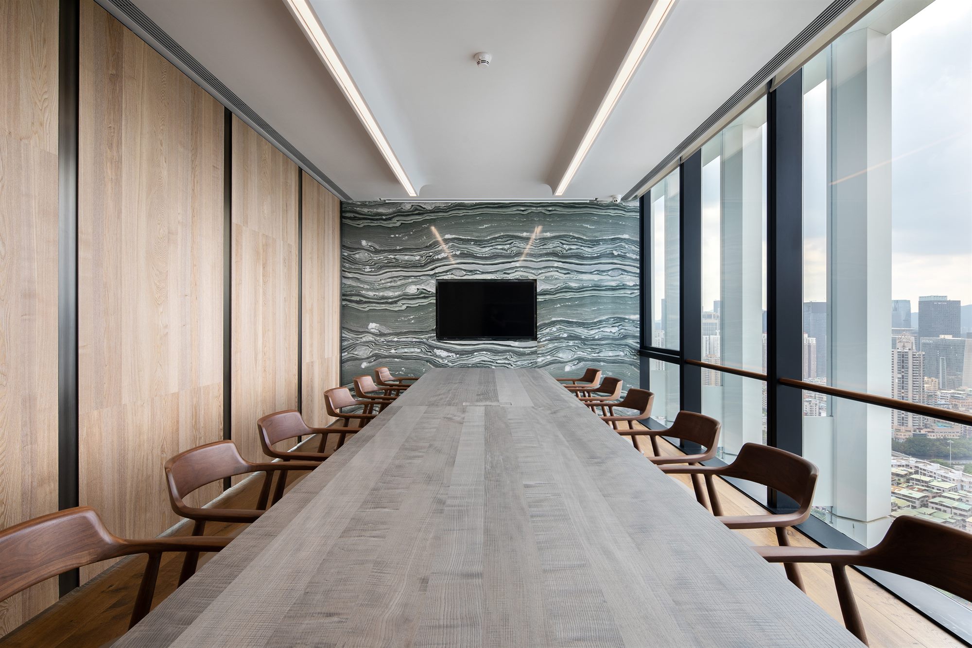 Boardroom with long table, stone feature wall and city views, Shenzhen Wenhua Architectural Construction office