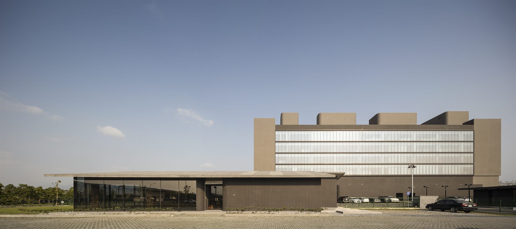 T-HAM factory front with glazed staff block and mountains behind, Pingtung