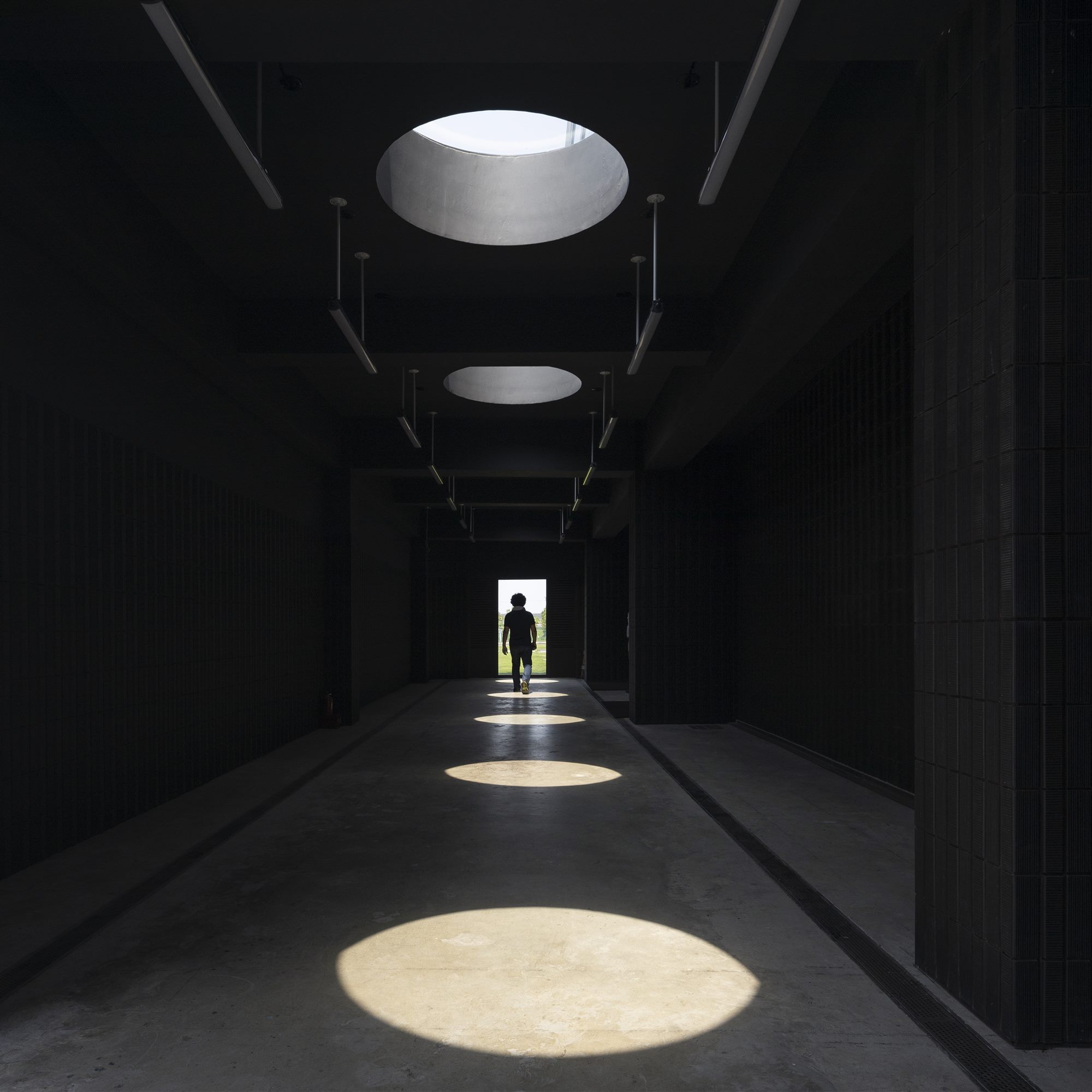 Workers' entrance tunnel lit by circular skylights inside the T-HAM factory