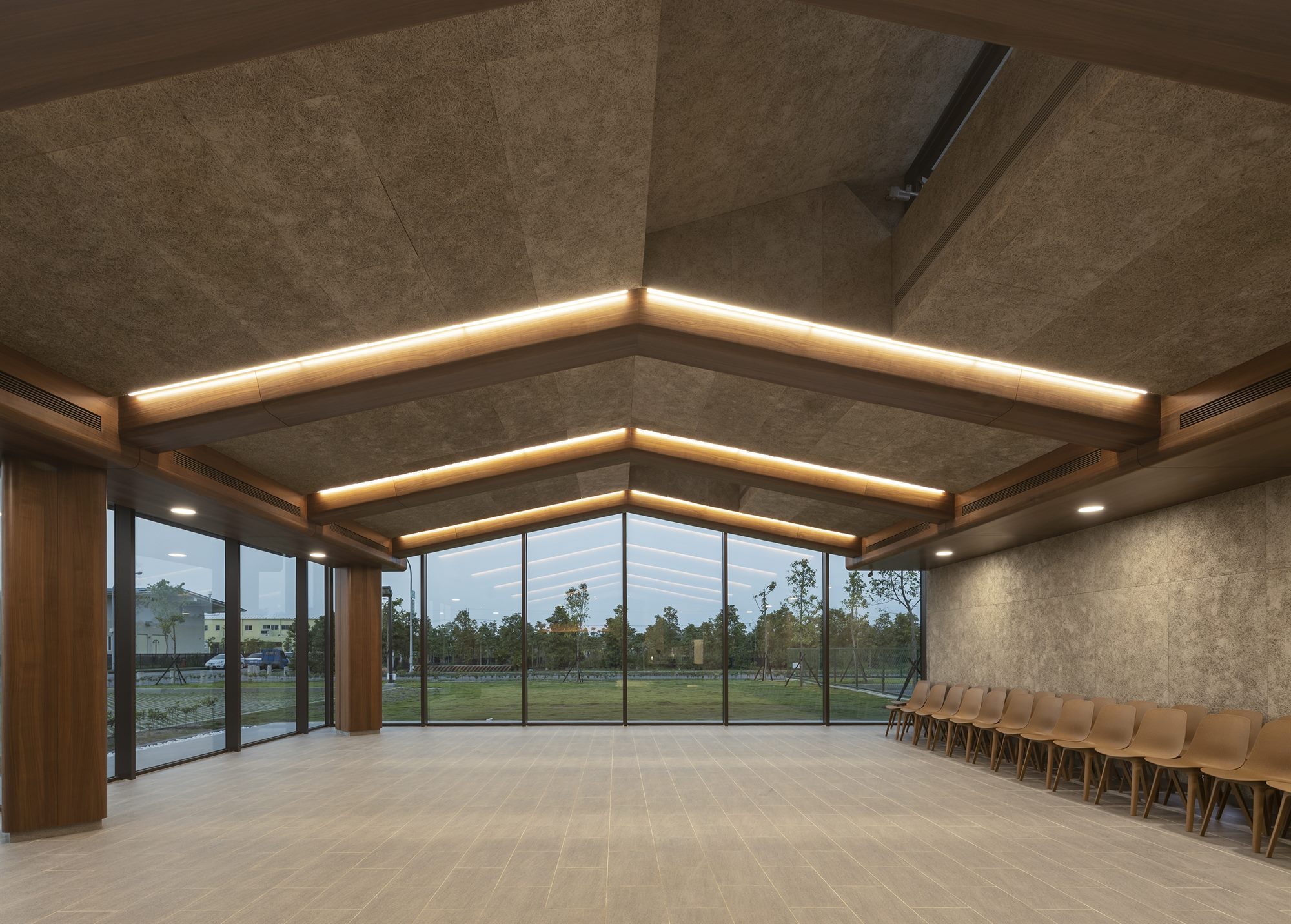 Timber-ceilinged hall with full-height windows onto the landscape, T-HAM shop and café building