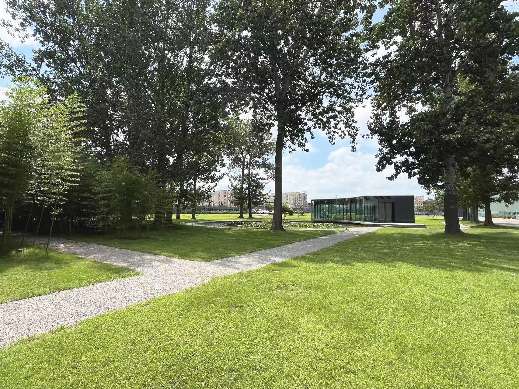 Path through lawn and trees towards the vacuum glass pavilion, Qingdao